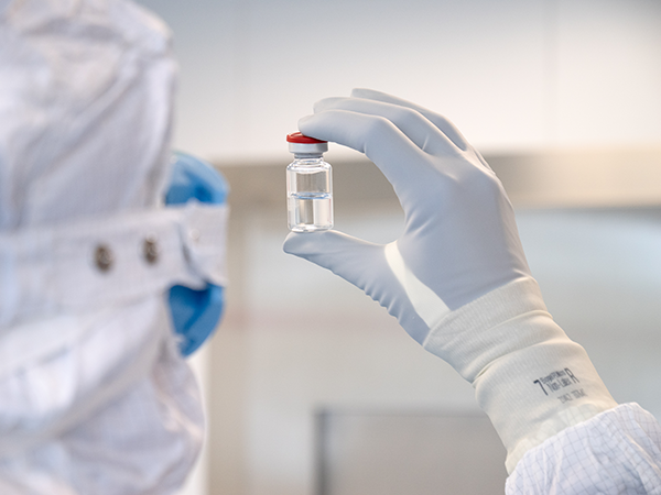 Scientist holding liquid sample with gloves on